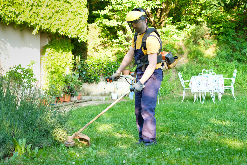 Safe operation of a string trimmer includes long pants, gloves, and a face shield.